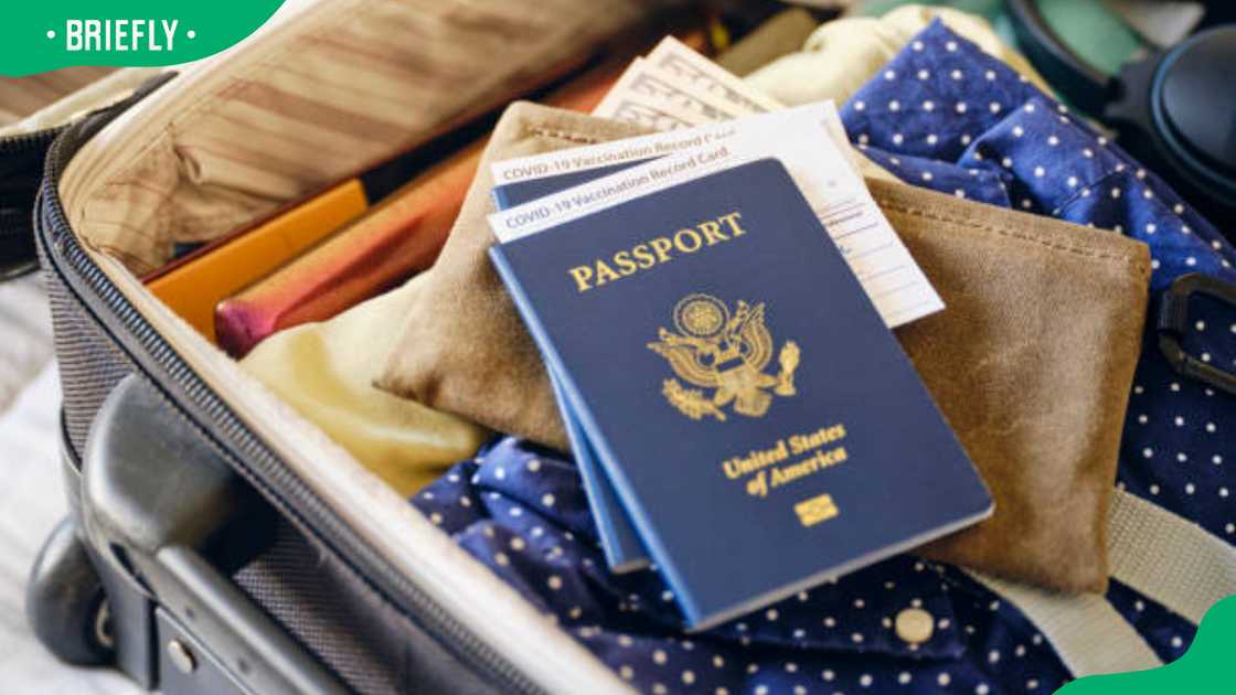 A traveller packing his bags and his travel documents