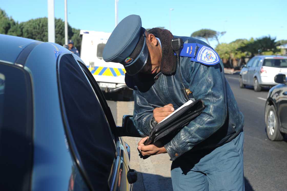 A traffic cop issuing a fine.