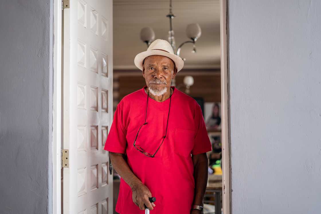 A man standing at the doorway with an expressionless face. A man standing at the doorway with an expressionless face.