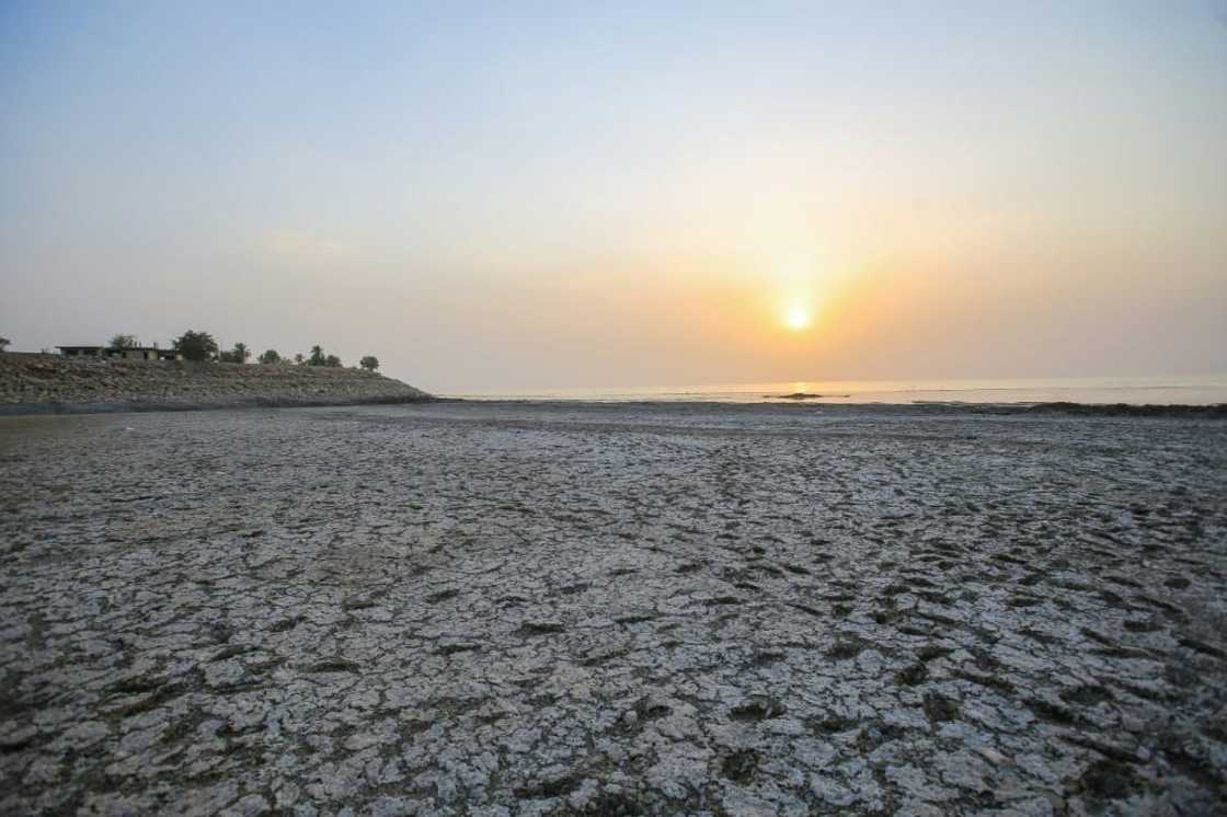 To get to the water, visitors must walk through foul-smelling mud that was once submerged under the lake surface