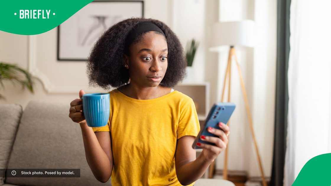 A shocked woman looking at her phone.