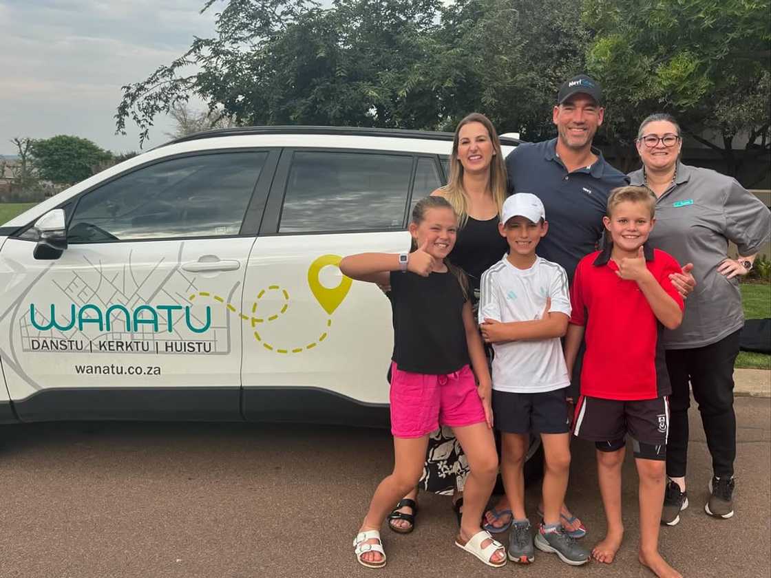 Family standing in front of a Wanatu vehicle.