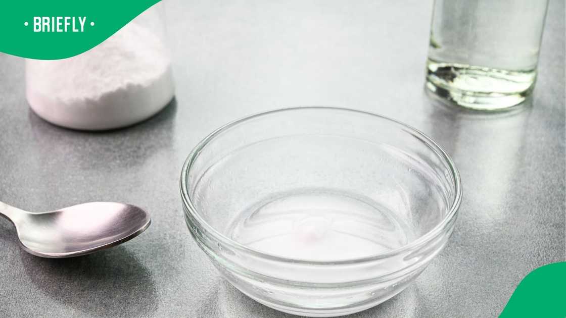 Mixing baking soda and vinegar in a glass bowl.