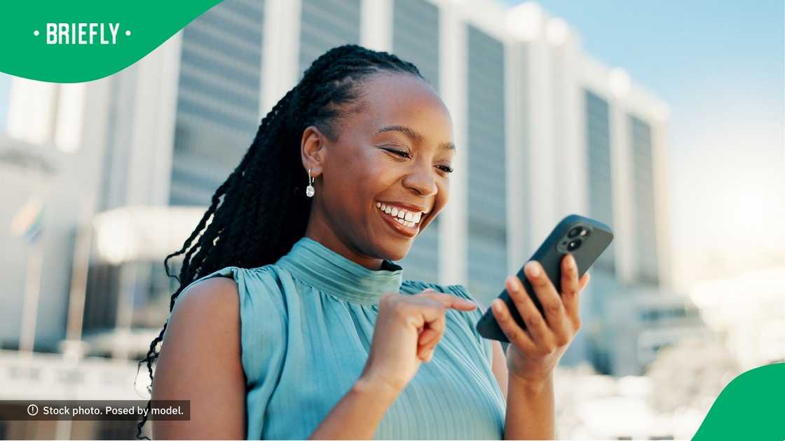 A woman smiling at her phone.