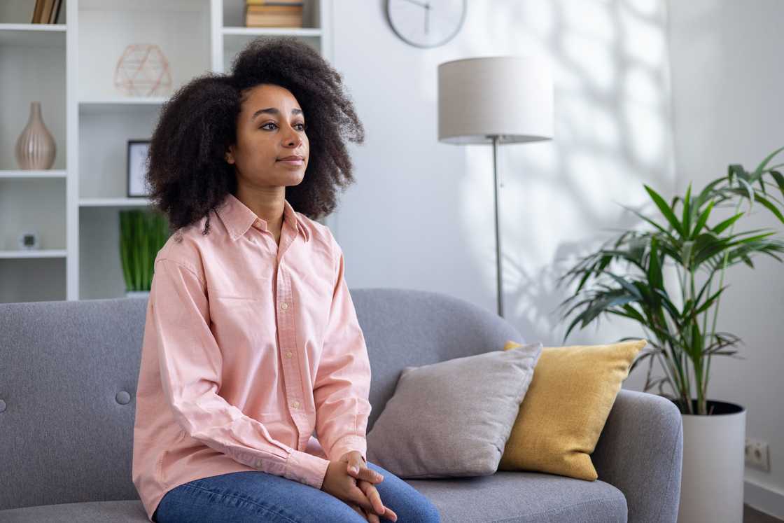 A young woman sitting on sofa in a modern living room A young woman sitting on sofa in a modern living room