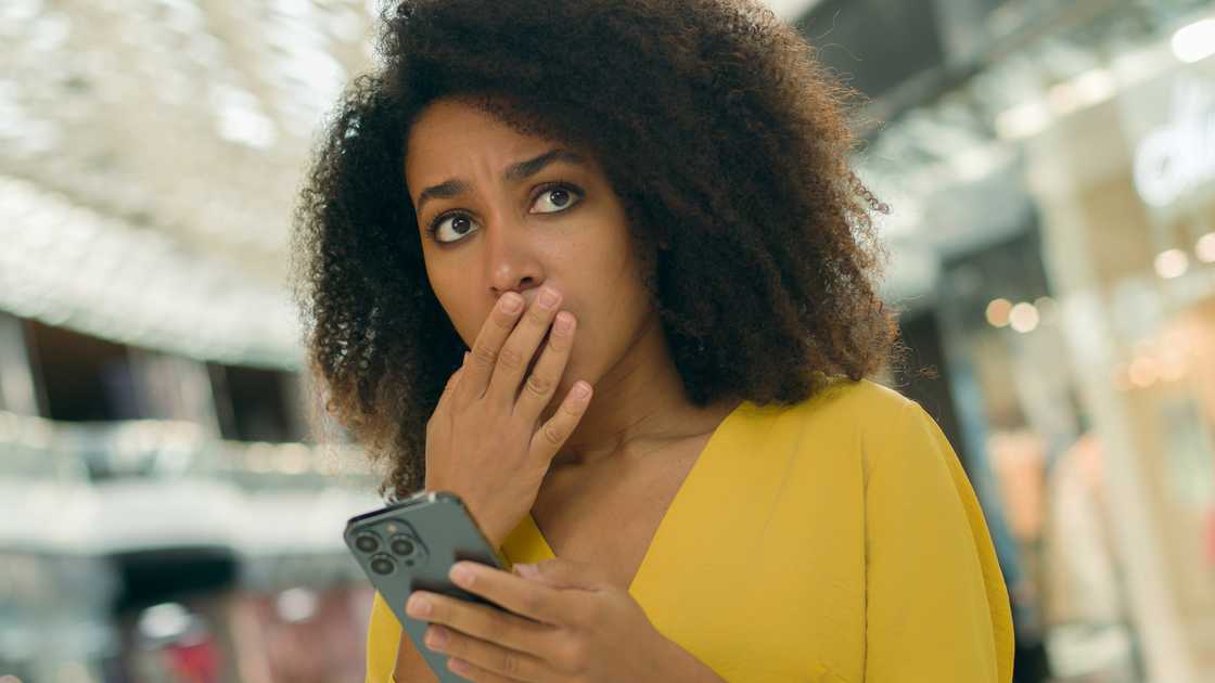 A shocked lady holds her phone