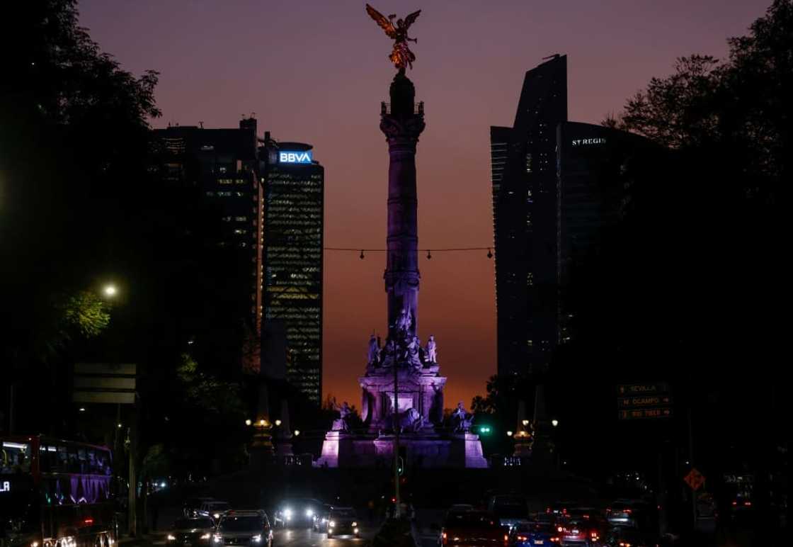 The sun sets behind the Angel of Independence monument in Mexico City