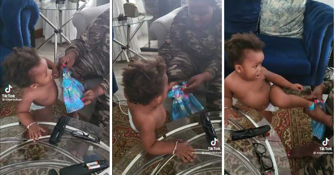 A baby had some of her family members pleading with her not to wear a doll's dress. A baby had some of her family members pleading with her not to wear a doll's dress.