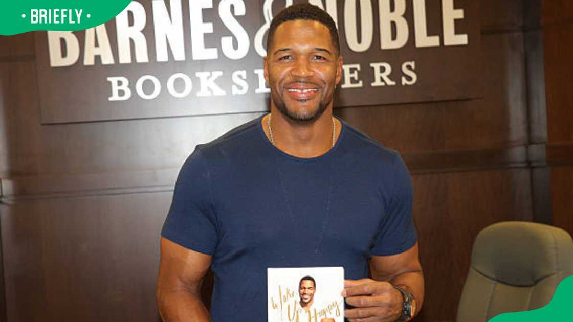 Michael Strahan with a copy of his new book