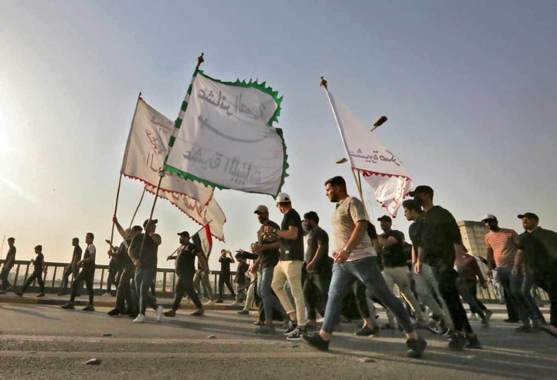 Supporters of Iraqi cleric Moqtada Sadr wave flags during a rally protesting a rival political bloc's nomination for prime minister on Monday Supporters of Iraqi cleric Moqtada Sadr wave flags during a rally protesting a rival political bloc's nomination for prime minister on Monday