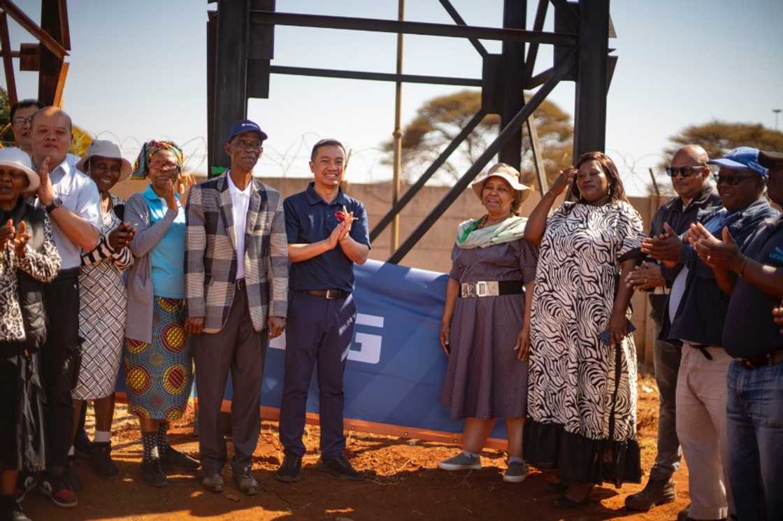 Li Yi , General Manager of LiuGong Africa with community members at the borehole.