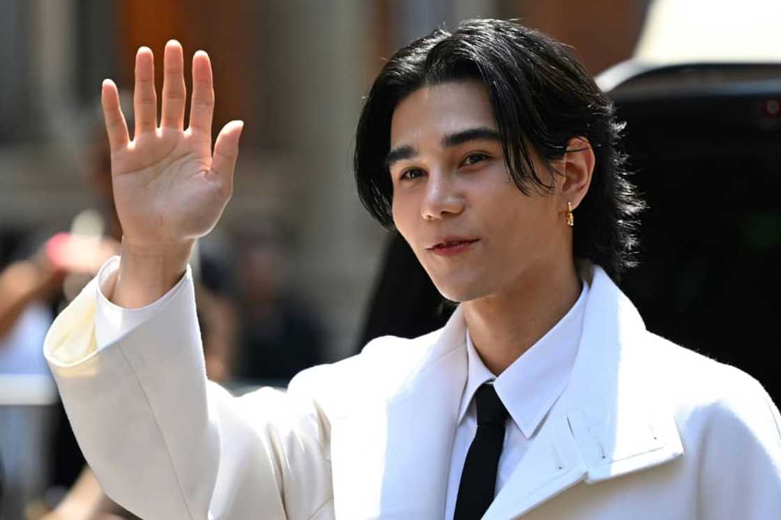 Artist Jeff Satur greets fans on his arrival at the Valentino men's show in Milan.