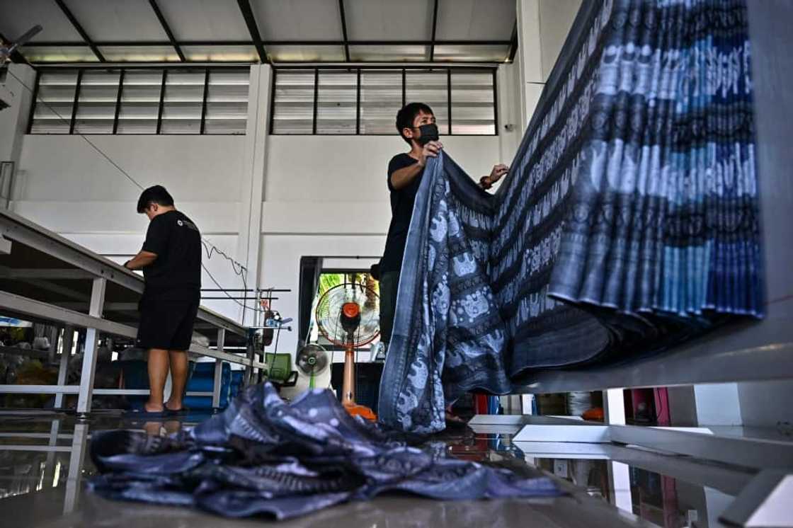 Workers in Chiang Mai prepare to cut elephant print fabric into clothing patterns Workers in Chiang Mai prepare to cut elephant print fabric into clothing patterns
