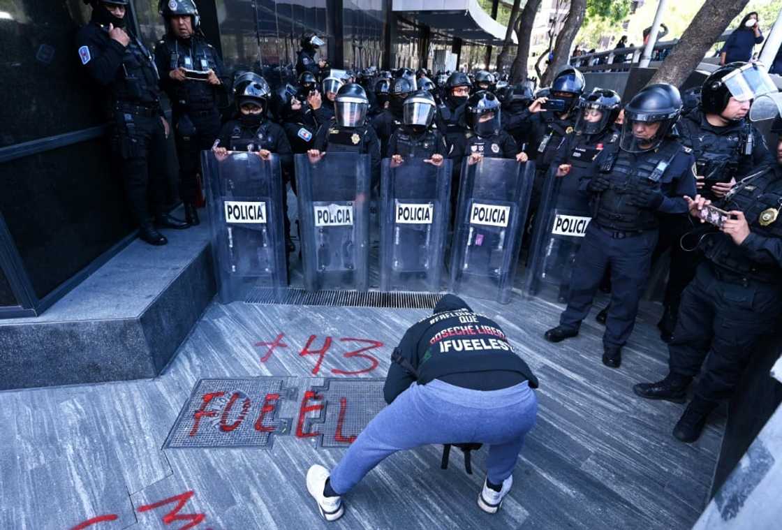 Protesters demanding justice for 43 Mexican students who disappeared in 2014 paint graffiti outside the attorney general's office in Mexico City Protesters demanding justice for 43 Mexican students who disappeared in 2014 paint graffiti outside the attorney general's office in Mexico City