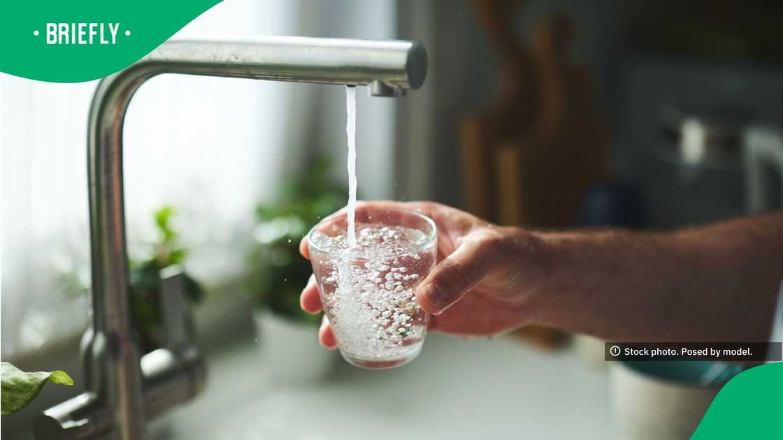 The picture showed a person pouring water in a glass The picture showed a person pouring water in a glass