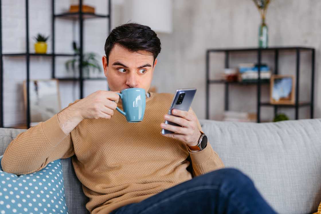 A shocked man looking at his phone.