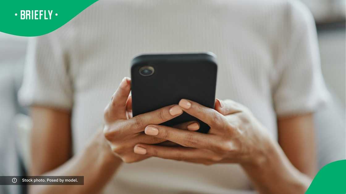 A woman typing on her phone. A woman typing on her phone.