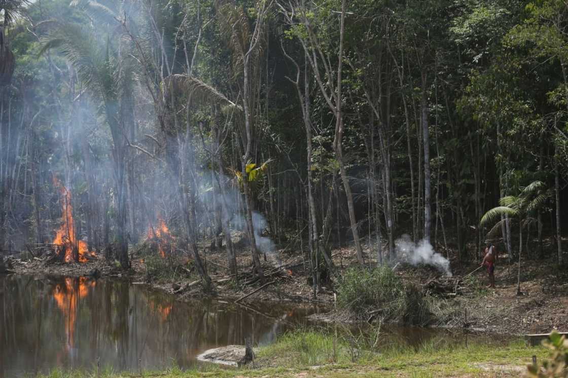 A man lights a fire on the edge of the Transamazonica highway in Manicoré, Amazonas state, Brazil, on September 23, 2022 A man lights a fire on the edge of the Transamazonica highway in Manicoré, Amazonas state, Brazil, on September 23, 2022
