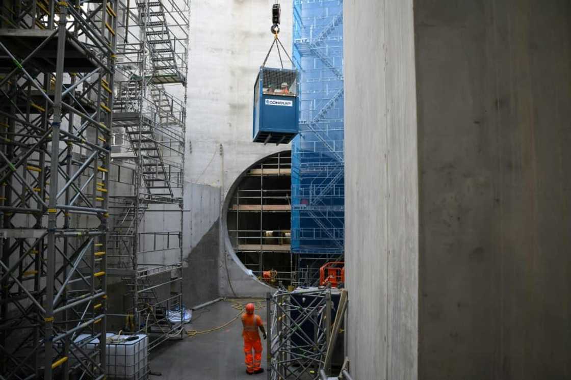 Construction workers are lowered 40 metres (130 feet) down a vertical shaft