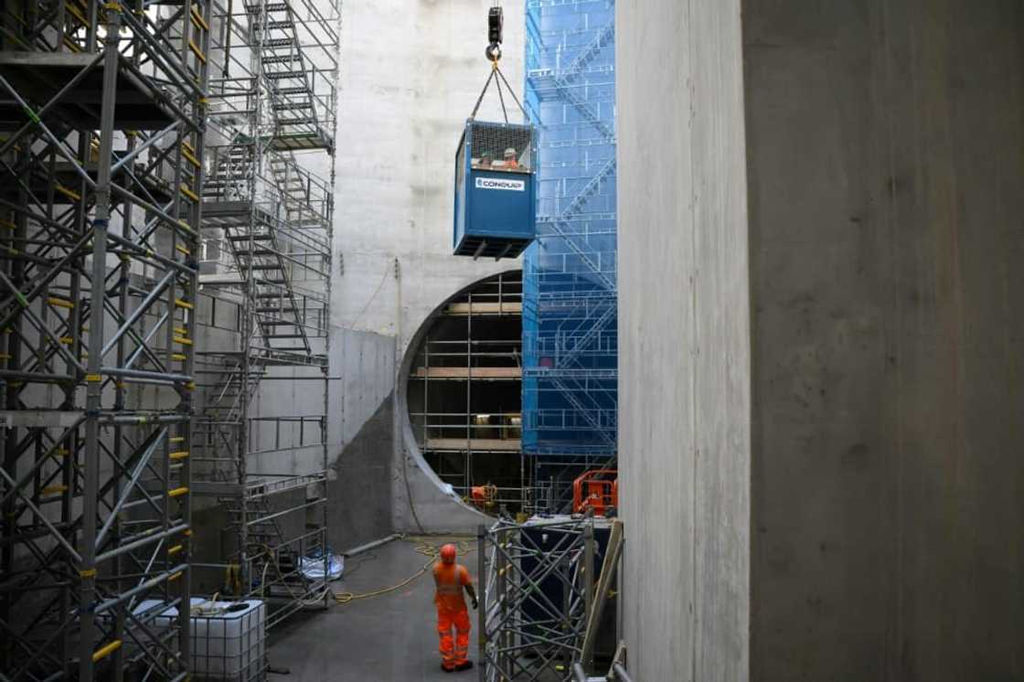 Construction workers are lowered 40 metres (130 feet) down a vertical shaft Construction workers are lowered 40 metres (130 feet) down a vertical shaft