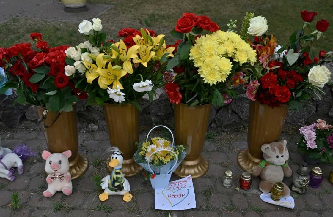 A makeshift shrine of candles, flowers and children's toys stands next to a destroyed mall in Kremenchuk on June 28, 2022, a day after it was hit by a Russian missile strike according to Ukrainian authorities.