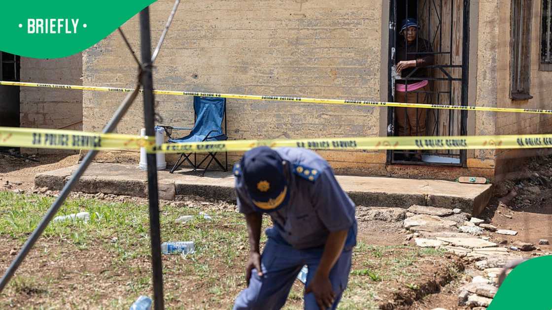 A resident looks on from the doorway of her home as a South African Police Service (SAPS) officer walks under police tape at the scene where gunmen armed with assault rifles stormed a bar in Johannesburg on September 27, 2026 A resident looks on from the doorway of her home as a South African Police Service (SAPS) officer walks under police tape at the scene where gunmen armed with assault rifles stormed a bar in Johannesburg on September 27, 2026