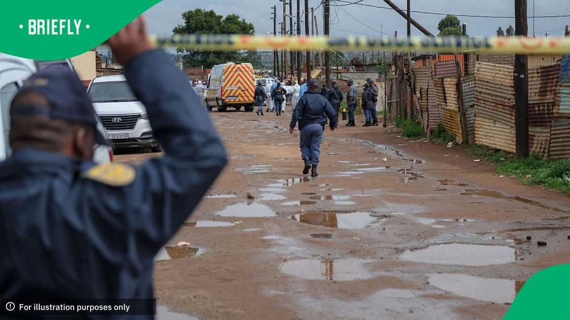 South African Police Service (SAPS) officers stand at the scene of an attack at a tavern in Bekkersdal on December 21, 2025