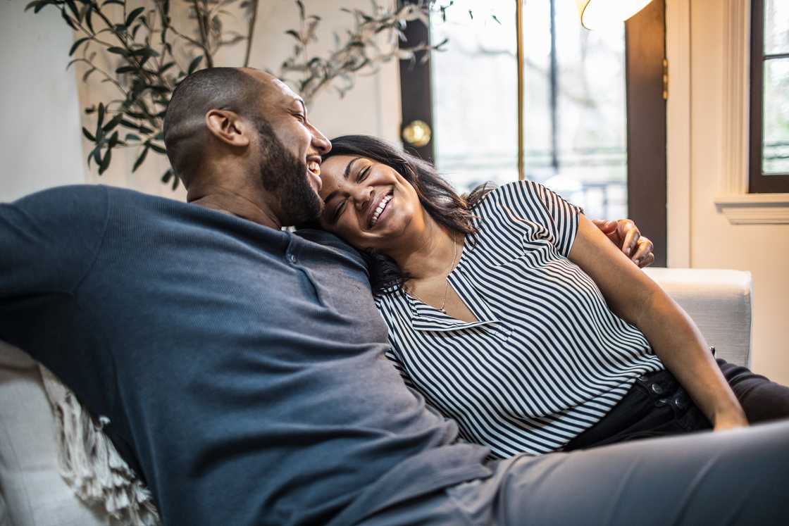 A stock photo of a married couple embracing on a sofa A stock photo of a married couple embracing on a sofa