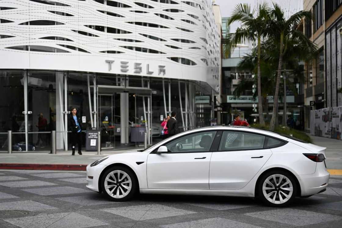 A Tesla electric vehicle drives past the Tesla Inc Santa Monica Place store, in Santa Monica, California