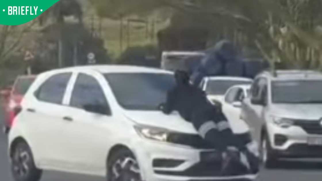 woman hangs onto bonnett woman hangs onto bonnett