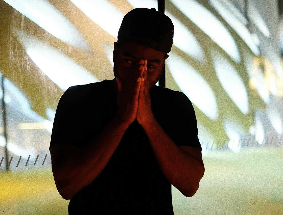 A young man posing in a pray sign