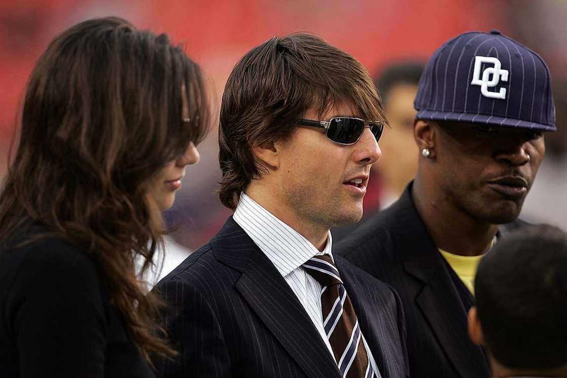 Tom Cruise, Katie Holmes and Jamie Foxx stand on the field before a game between the Minnesota Vikings and the Washington Redskins Tom Cruise, Katie Holmes and Jamie Foxx stand on the field before a game between the Minnesota Vikings and the Washington Redskins