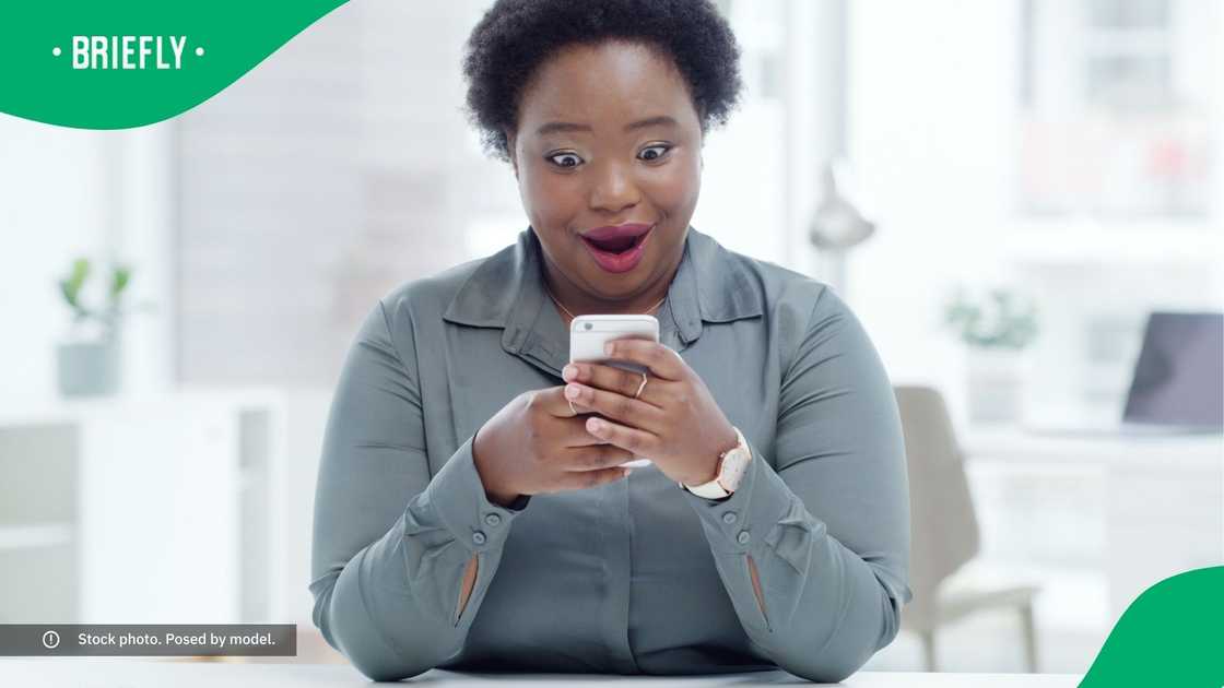 A surprised woman looking at her phone. A surprised woman looking at her phone.