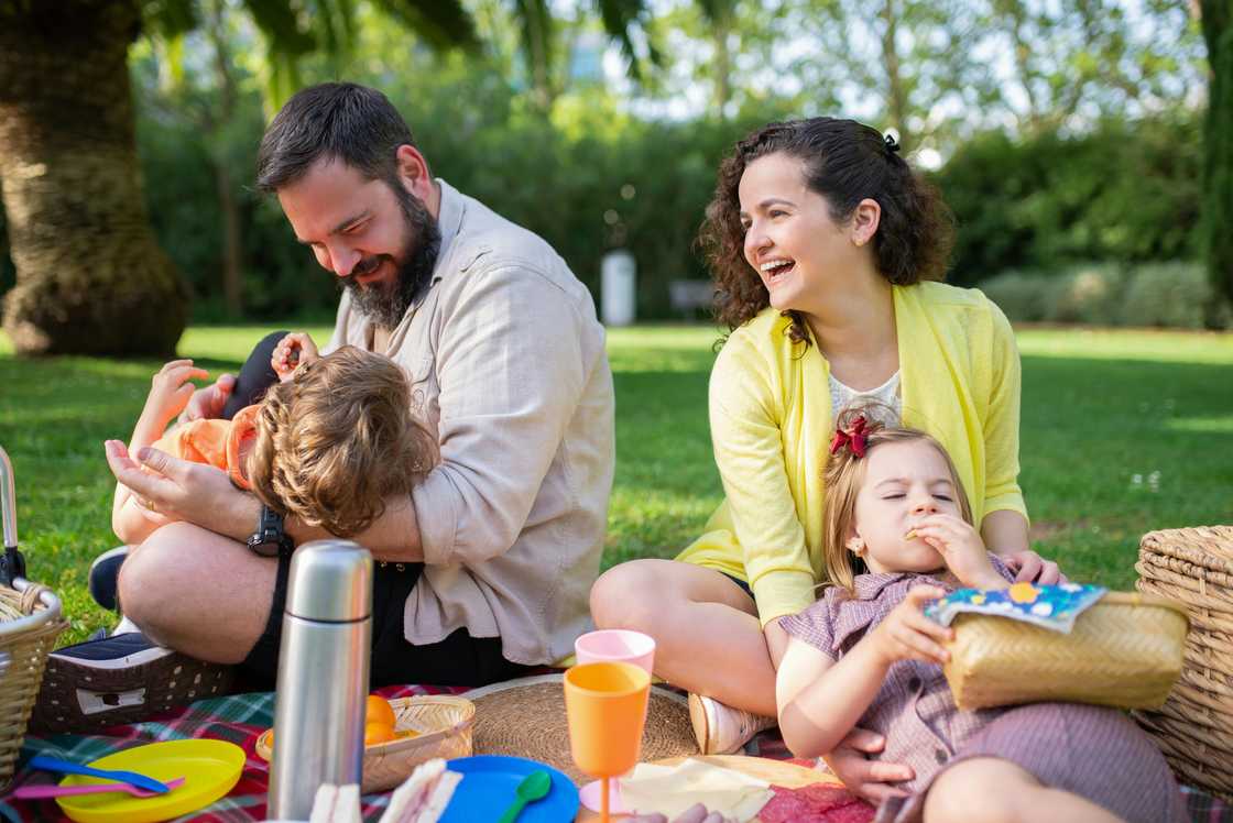 A happy family of four is pictured on a picnic