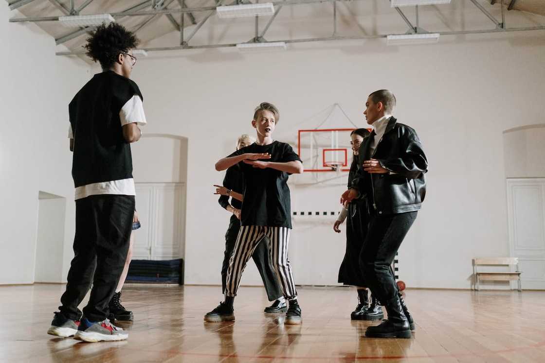 Students in black and white outfits dancing