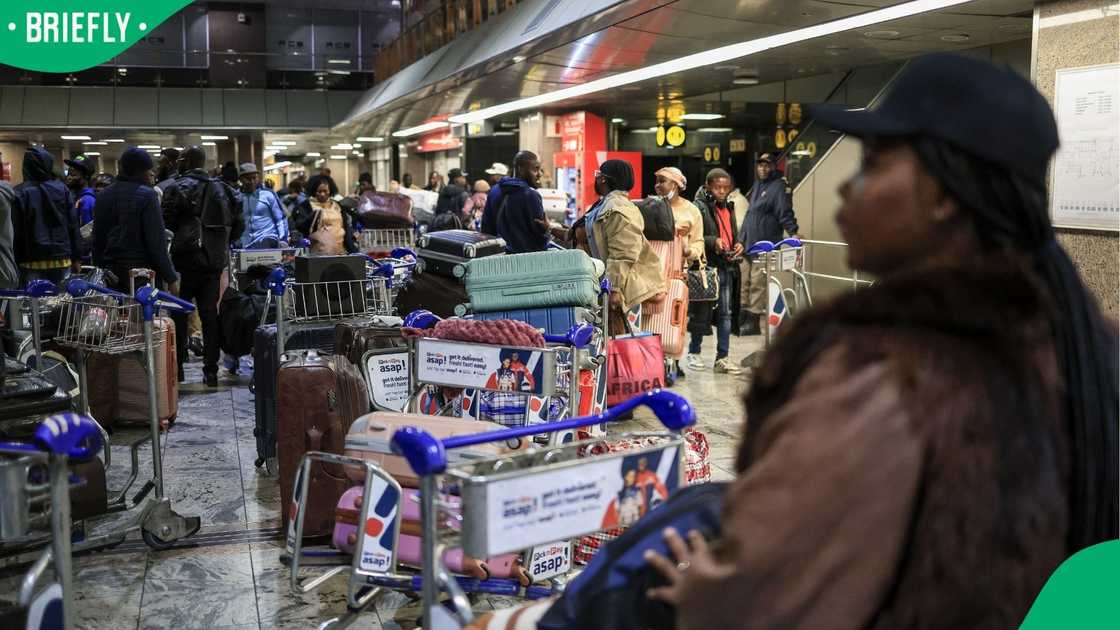 Ghanaian nationals stand at the check-in desk for an evacuation flight at OR Tambo International Airport Ghanaian nationals stand at the check-in desk for an evacuation flight at OR Tambo International Airport