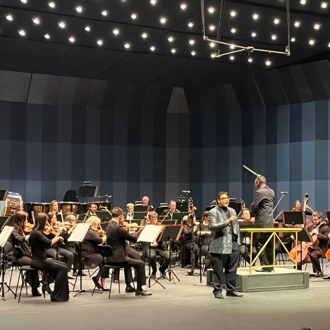 A singer singing with an orchestra. A singer singing with an orchestra.