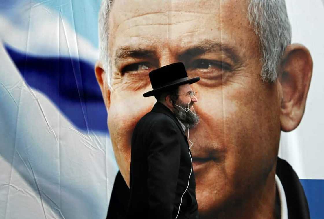 An Ultra Orthodox Jewish man walks past an electoral billboard bearing a portrait of Israel's then prime minister Benjamin Netanyahu back in 2019 -- one of the many national polls Israelis have voted in during recent years An Ultra Orthodox Jewish man walks past an electoral billboard bearing a portrait of Israel's then prime minister Benjamin Netanyahu back in 2019 -- one of the many national polls Israelis have voted in during recent years