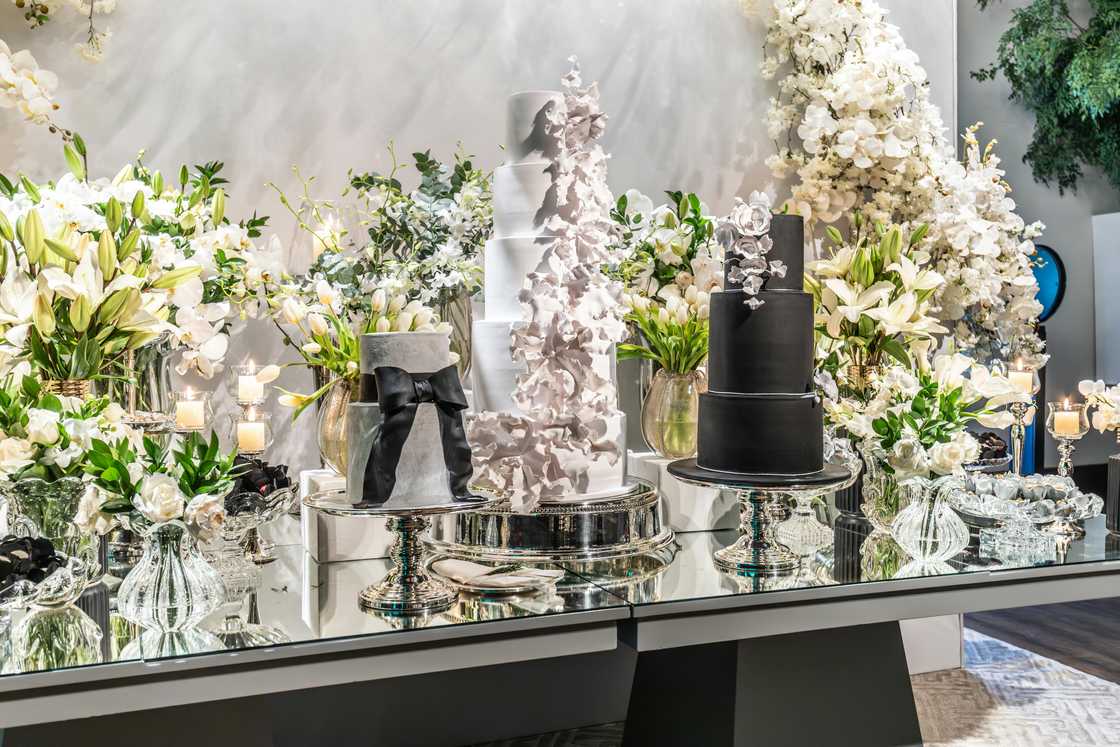 A well decorated wedding cakes and lillies on a table