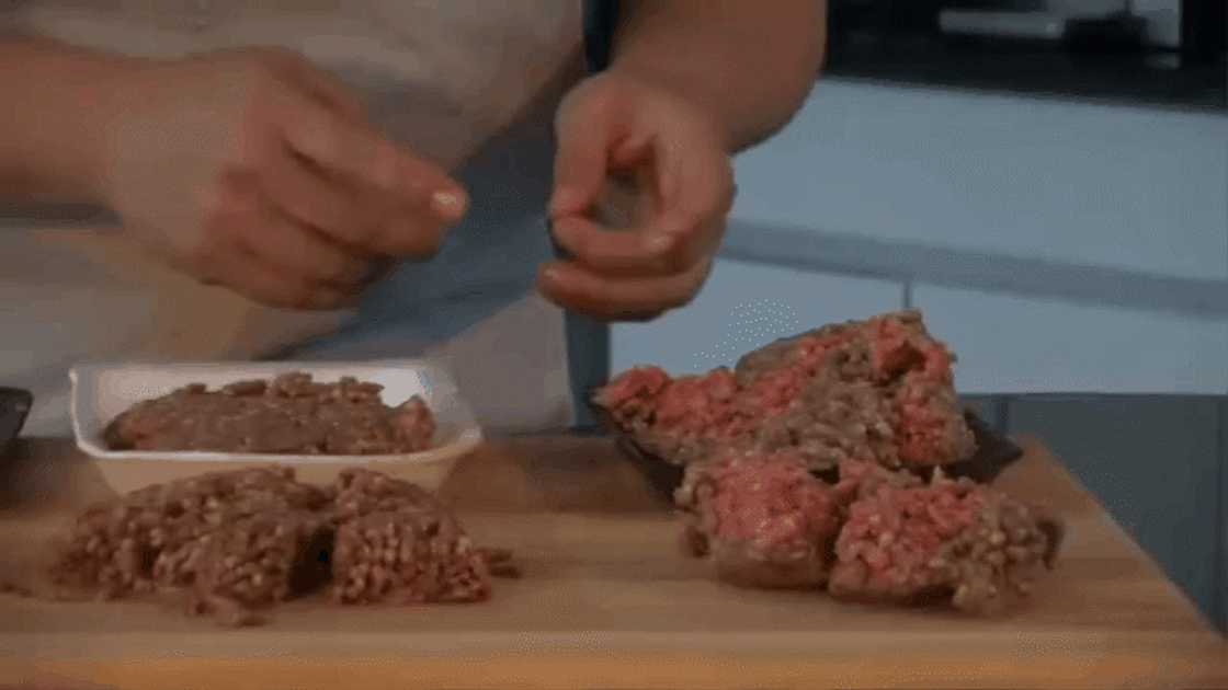 A chef illustrating how to know if meat has spoiled by colour.