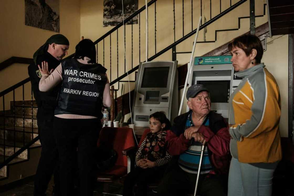 District war crimes prosecutor Kateryna Shevtsova (2nd L) talks with a police officer as she investigates the torture claims District war crimes prosecutor Kateryna Shevtsova (2nd L) talks with a police officer as she investigates the torture claims