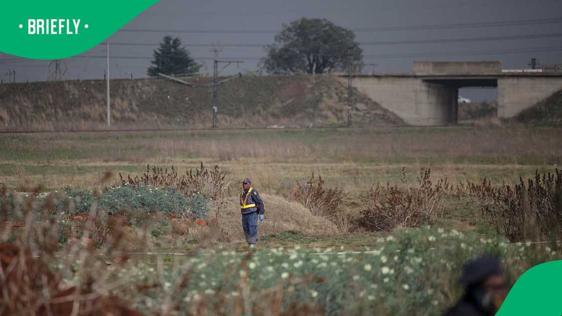 South African Police Service (SAPS) officers stand guard at the crime scene where the body of a woman was discovered in Boksburg on September 17, 2026