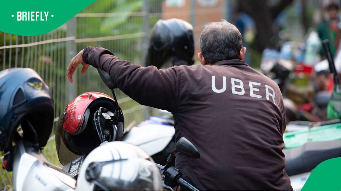 A man wearing an Uber jacket. A man wearing an Uber jacket.