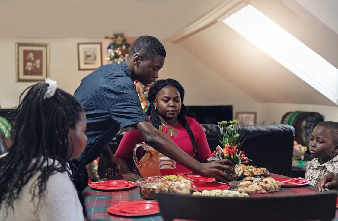 Family gathers around a holiday table with festive dishes. Family gathers around a holiday table with festive dishes.