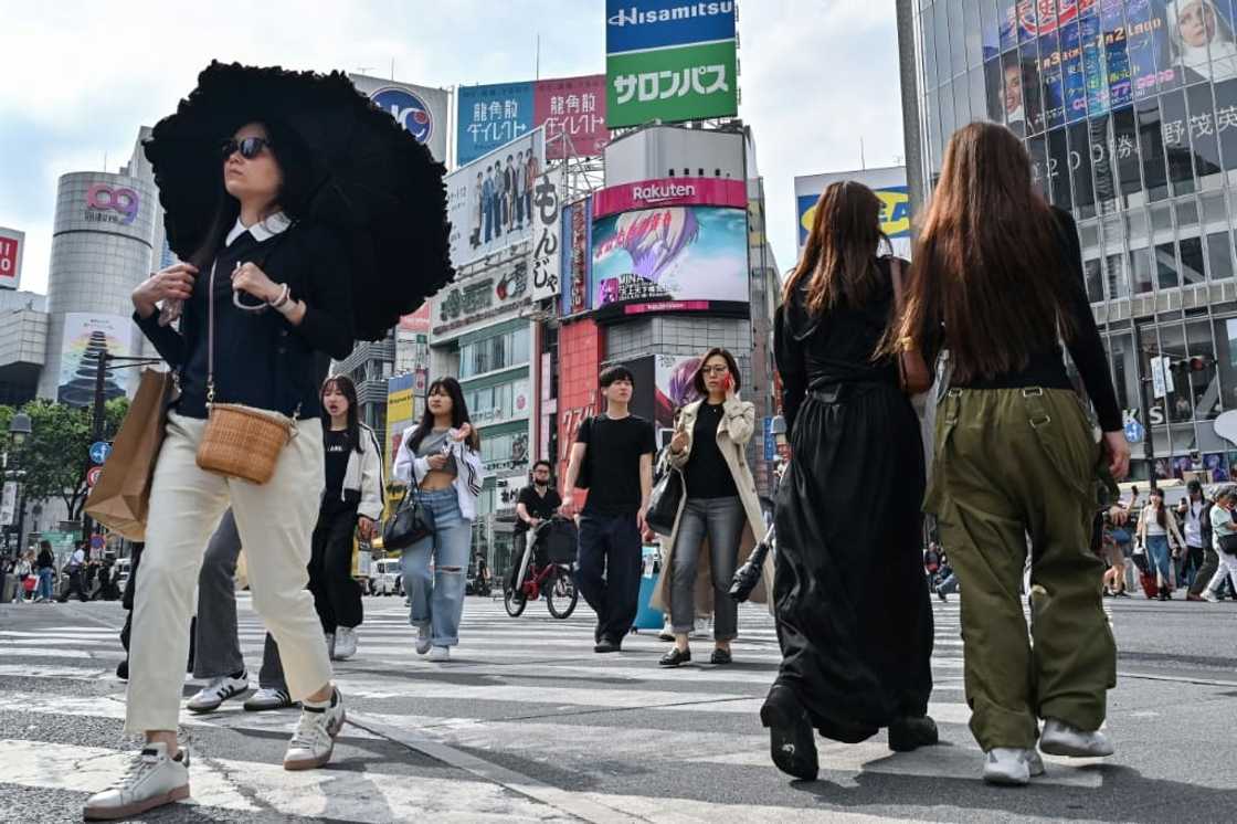 Pedestrians cross the intersection at Shibuya Crossing in Tokyo Pedestrians cross the intersection at Shibuya Crossing in Tokyo