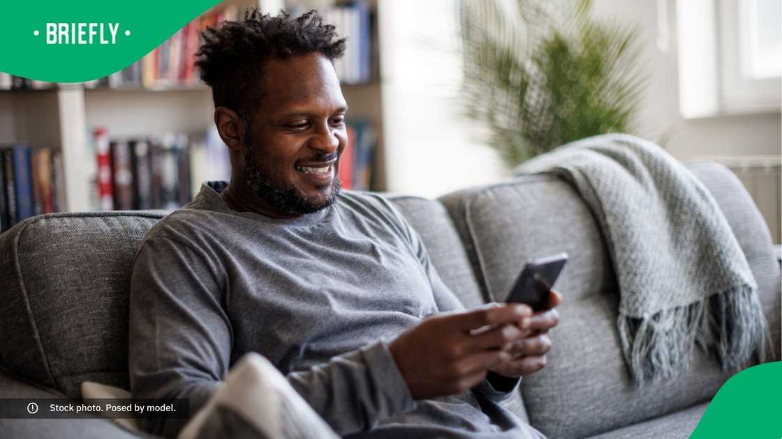A man smiling at his phone. A man smiling at his phone.