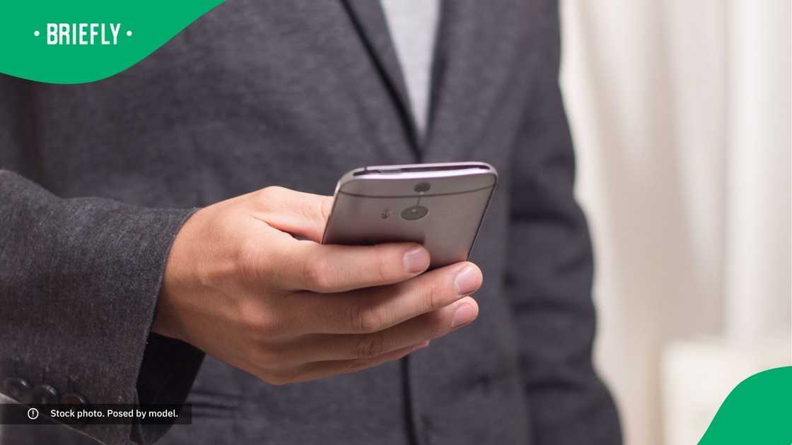 A man typing on his phone. A man typing on his phone.