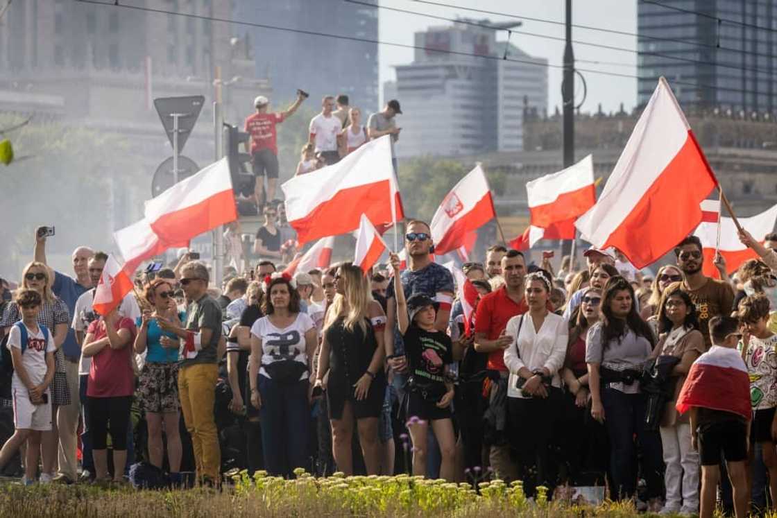 People wave Polish flags during an event on August 1, 2022 to mark the 78th anniversary of the Warsaw Uprising People wave Polish flags during an event on August 1, 2022 to mark the 78th anniversary of the Warsaw Uprising