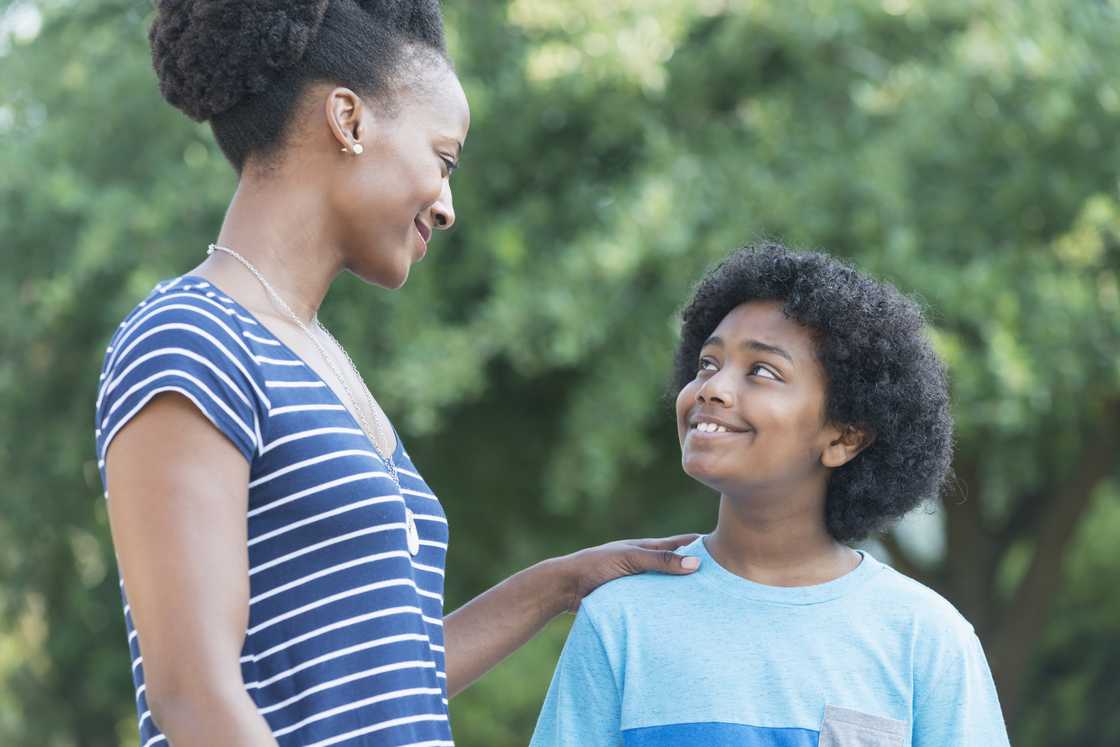 A mother and son looking at each other, smiling A mother and son looking at each other, smiling