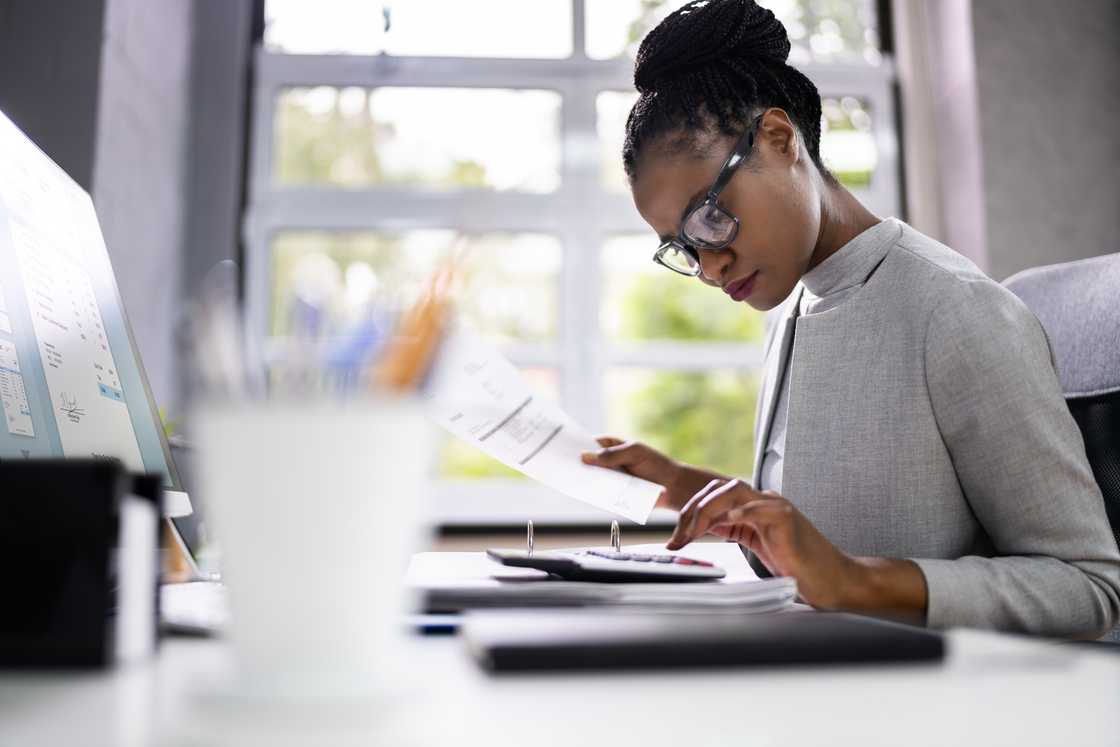 A woman using calculator inside office